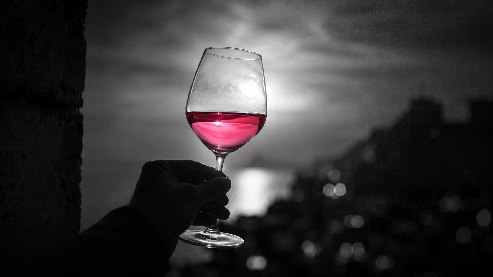 Ein Glas goldener Chardonnay im Gegenlicht, Schwarzweiß, der Wein leuchtet magenta
